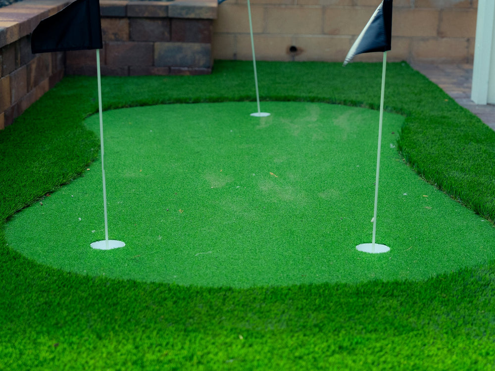 Artificial turf putting green with three flags in a Las Vegas backyard